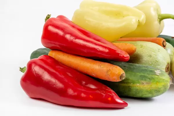 Rote Paprika, Karotten und Zucchini vor weißem Hintergrund