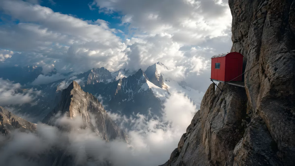 Rote Schutzhütte an steiler Felswand in den Alpen