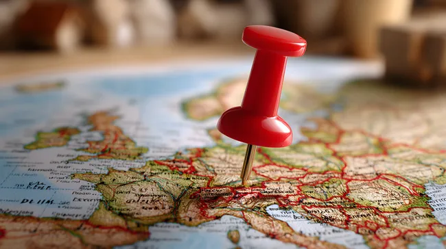 Rote Stecknadel auf Europakarte zeigt Reiseziel