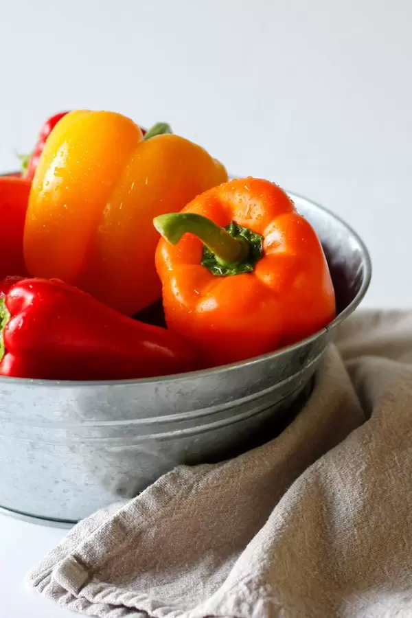 Rote und gelbe Paprika in Metallschale