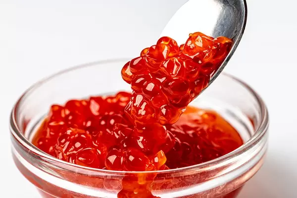 Roten Kaviar in eine Glasschüssel schütten. Nahaufnahme