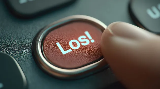 Roter Druckknopf mit Aufschrift 'Los!' in modischem Design