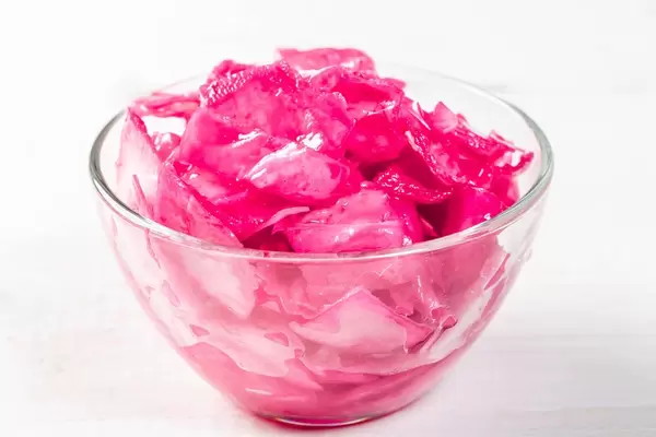 Roter eingelegter Kohl in Glasschale freigestellt vor weißem Hintergrund