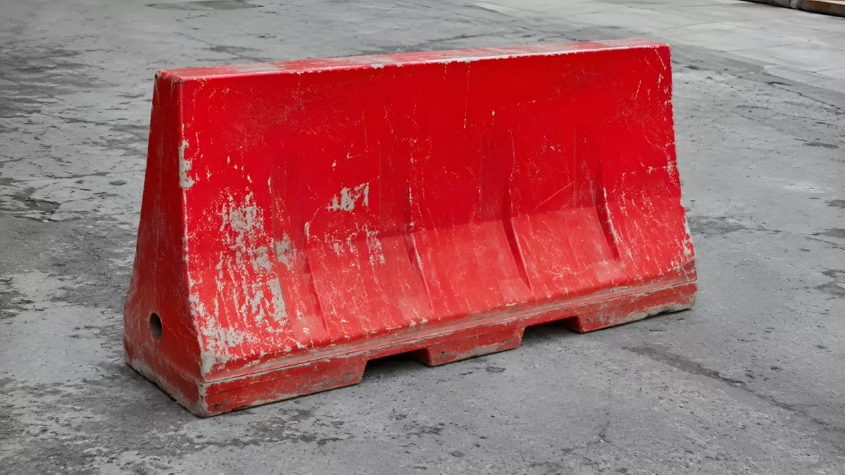 Roter Fahrbahnteiler aus Kunststoff auf Asphalt