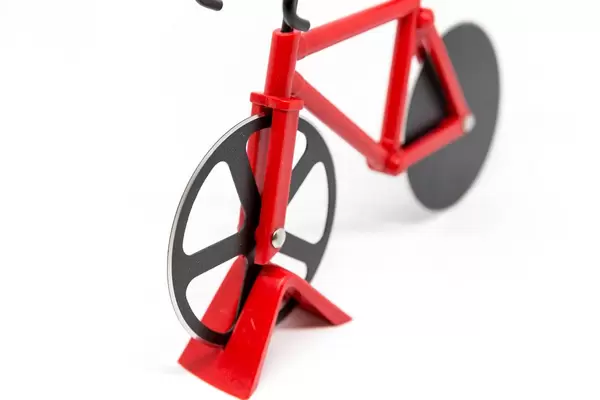 Roter Fahrrad-Pizzaschneider vor weißem Hintergrund