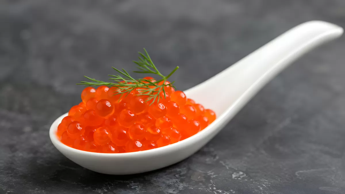 Roter Lachskaviar auf weißem Porzellanlöffel
