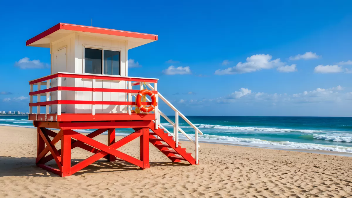 Roter Rettungsturm am sonnigen Sandstrand mit Meer