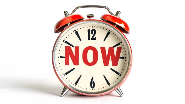 Roter Wecker mit Aufschrift 'NOW' - Konzept der Dringlichkeit