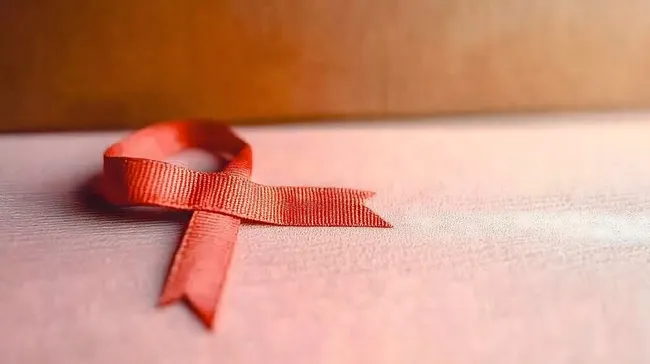 Rotes Aids-Bewusstseinssymbol auf Rosé-Hintergrund