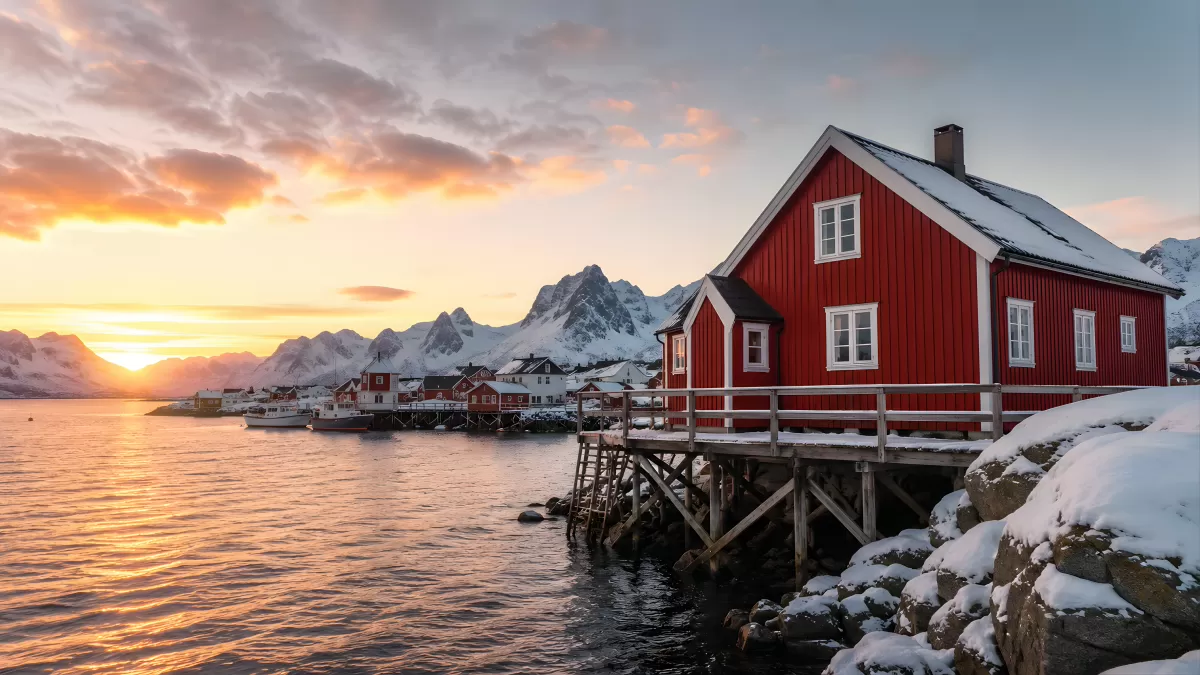 Rotes Bootshaus auf Stelzen in norwegischem Fjord