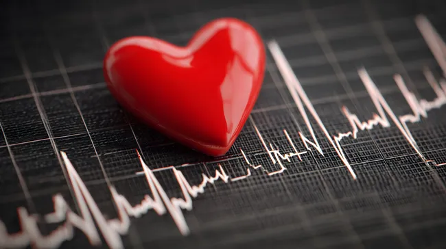 Rotes Herz auf EKG-Diagramm im Dunkeln