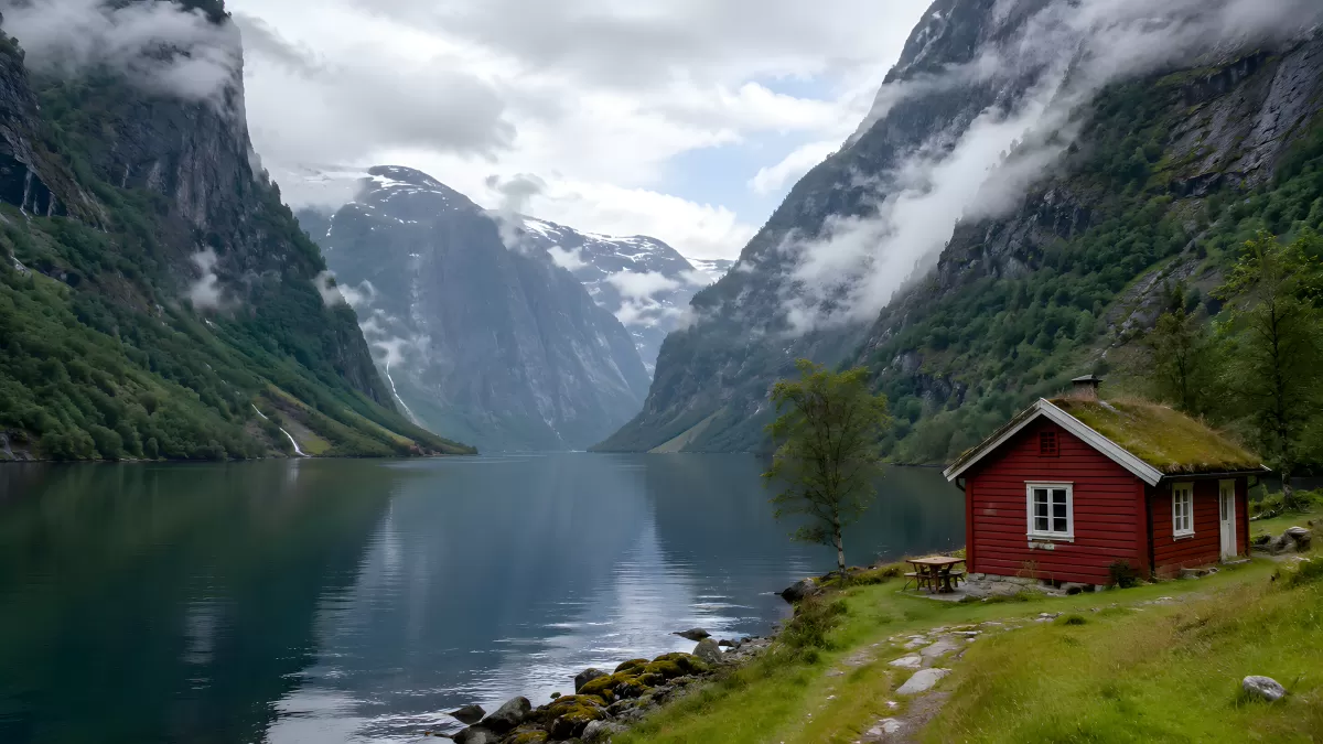Rotes Holzhaus am norwegischen Fjord mit Bergpanorama