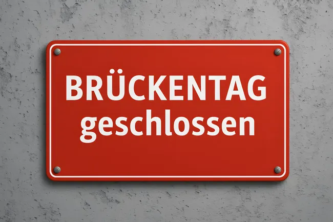 Rotes Schild zeigt 'Brückentag geschlossen' an Betonwand