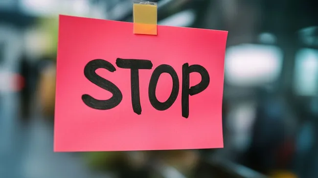 Rotes Warnschild mit Stop-Schriftzug am Bürofenster