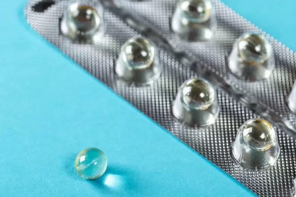 Round capsules in a blister on a blue background