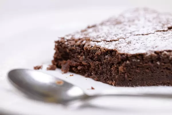 Round Chocolate cake slice with powdered sugar on the plate