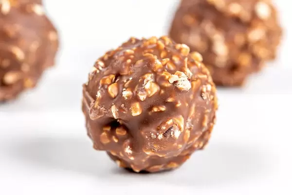 Round chocolates with chopped hazelnuts
