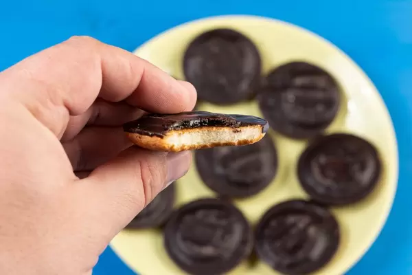 Round Cookie with Chocolate and Orange in the hand