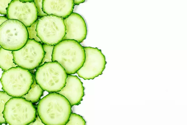 Round cucumber slices on a white background with free space