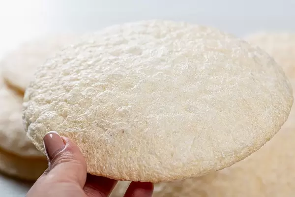 Round diet rice bread in a woman's hand close-up