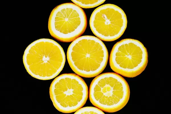 Round orange fruit slices on black background