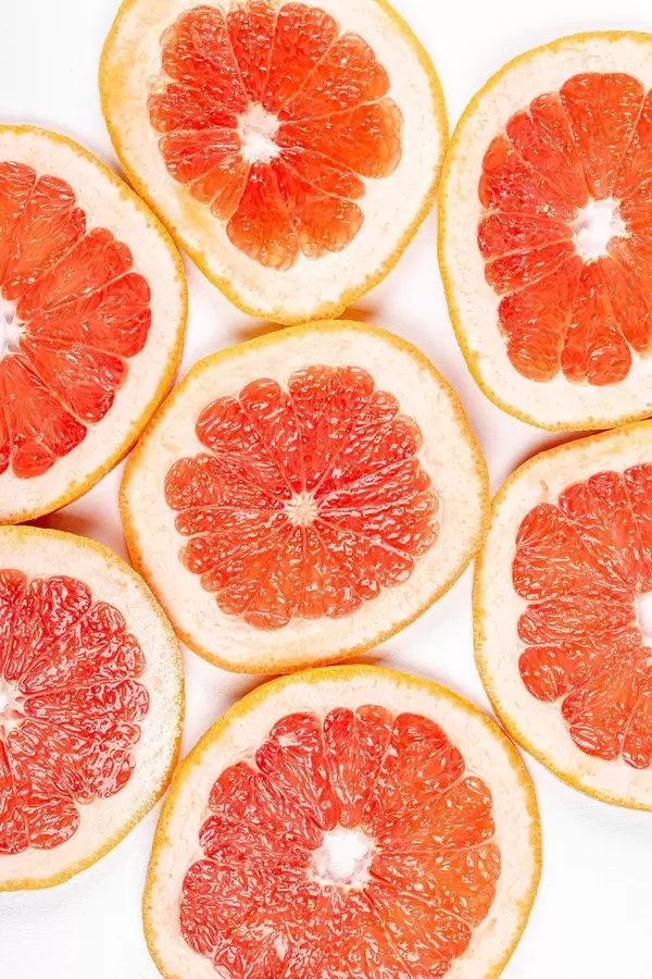 Round pieces of fresh grapefruit on a white background, top view (Flip 2020)