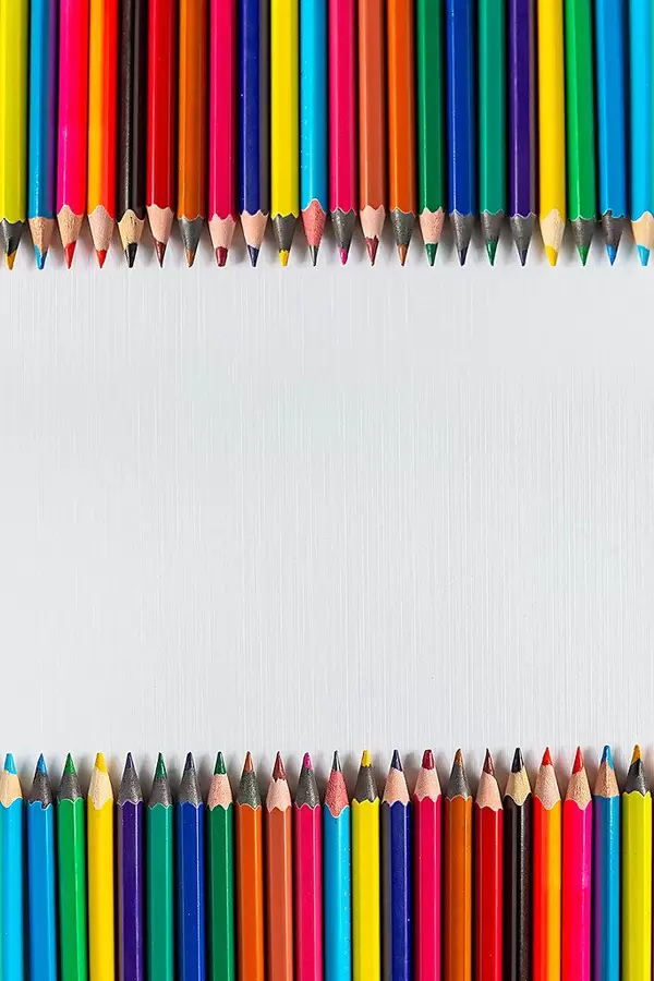 Rows of color pencils on a blank white paper