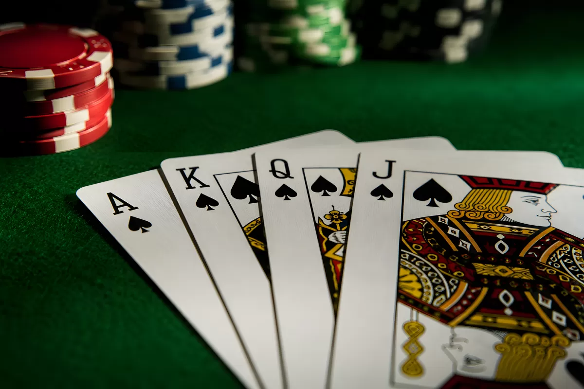 Royal Flush Pik auf grünem Pokertisch mit Chips
