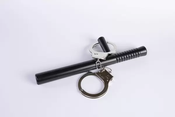 Rubber baton and handcuffs on a white background