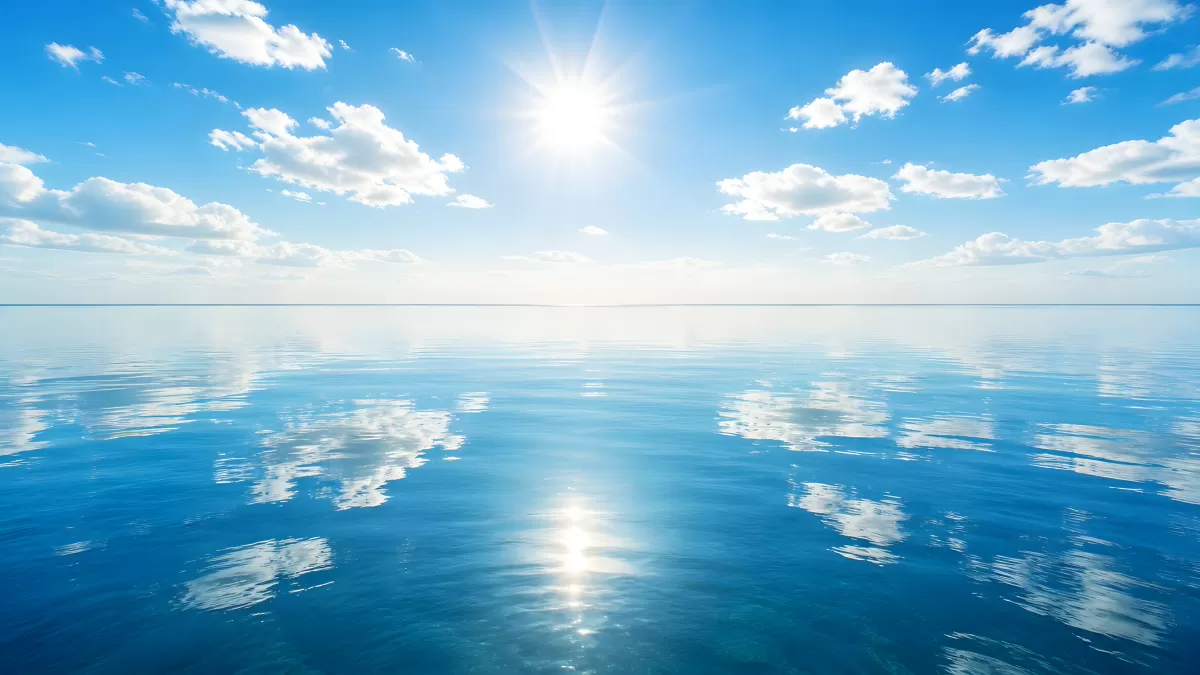 Ruhiges Meer mit Sonnenspiegelung und blauem Himmel