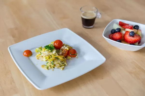 Rührei mit Tomaten, Obstsalat und Espresso