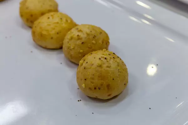 Runde Käsebällchen mit Schinkenfüllung auf einem weißen Teller