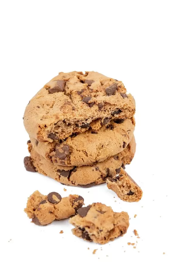 Runde Plätzchen mit Schokoladenstücken und Krümmel, auf einer weißen Oberfläche