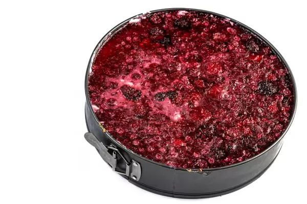 Runder Himbeerkäsekuchen über weißem Hintergrund