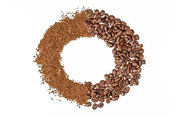 Runder Kaffee-Rahmen vor weißem Hintergrund. Aufnahme von oben