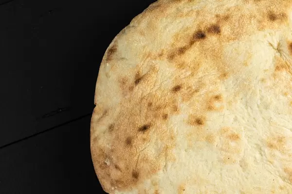 Rundes Brot über schwarzem Tisch