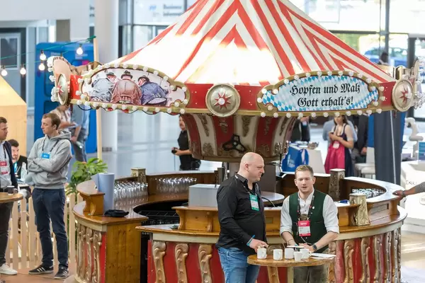 Rundes Oktoberfest-Bierzelt mit festlichen Lichtern und Schriftzug "Hopfen und Malz - Gott erhalt's!"