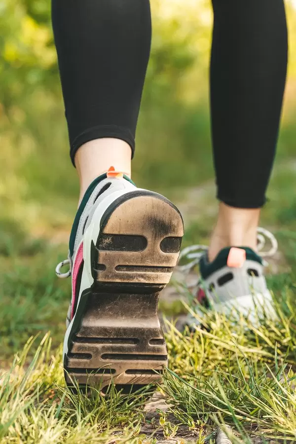 Runner woman feet running on road closeup on shoe. Sports healthy lifestyle concept