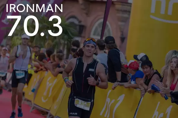 Runners on the last meters of the marathon, passing applauding spectators, next to picture title "Ironman 70.3"