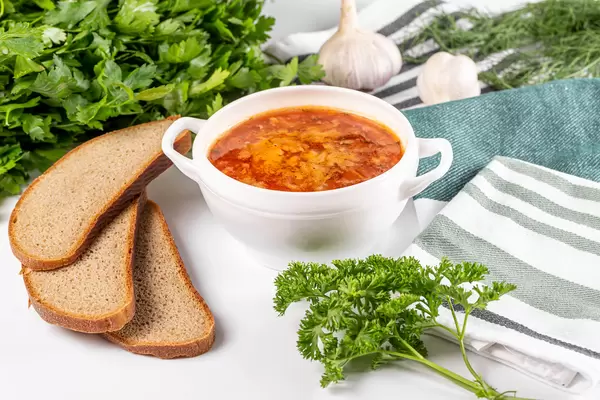 Russian borsch with garlic, fresh parsley and slices of black bread