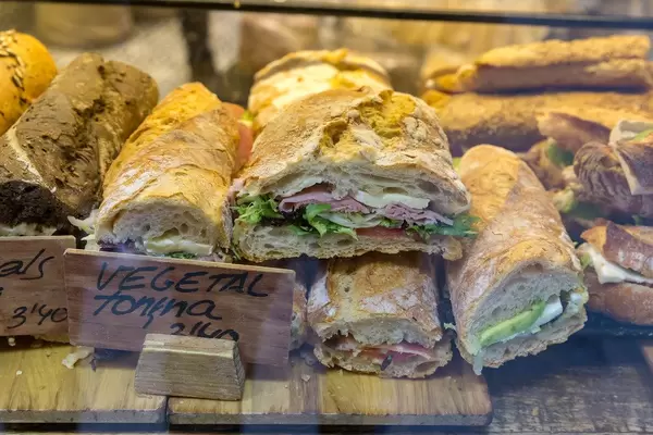Rustikale Baguettes in einer Auslage in Barcelona (Spanien), belegt mit Salat, Wurst, Käse und Gemüse