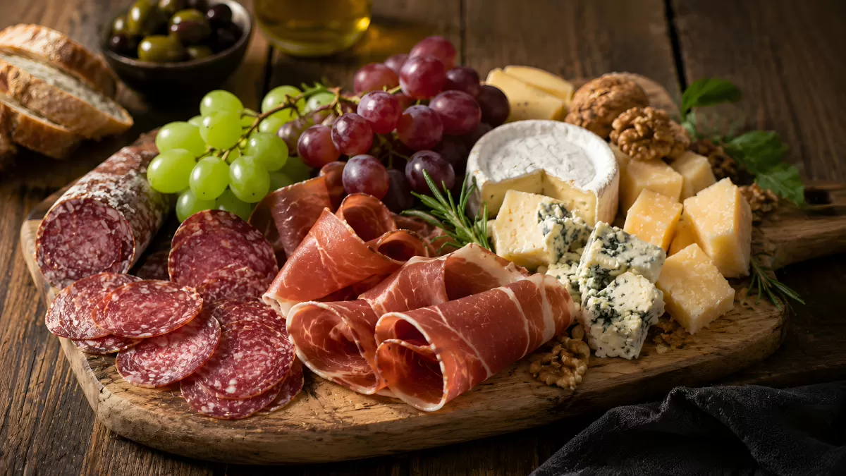 Rustikales Wurstbrett mit Käse, Schinken und Trauben