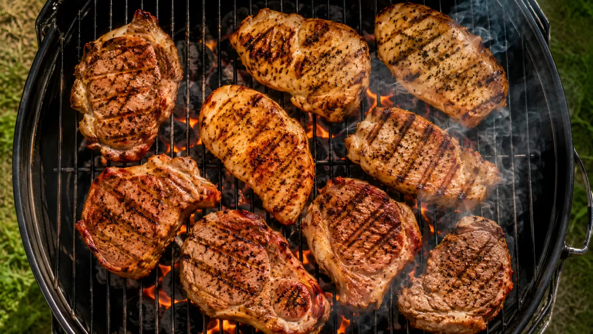 Saftige Fleischstücke auf dem Holzkohlegrill im Garten