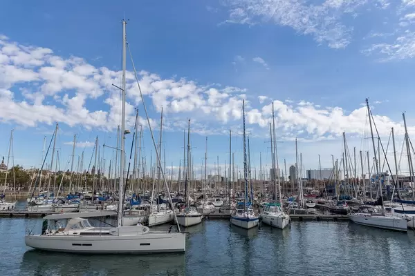 Sailboats at harbour Port Vell, next to promenade Rambla de Mar in Catalonia, Barcelona (Spain)