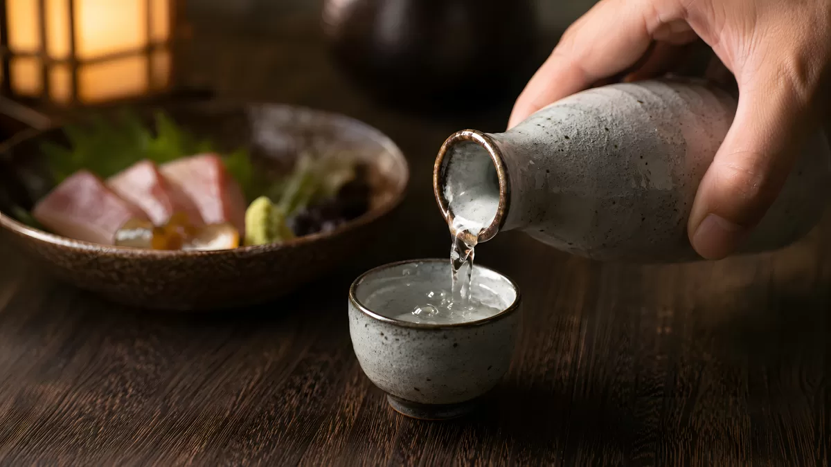 Sake wird in eine Keramikschale eingeschenkt