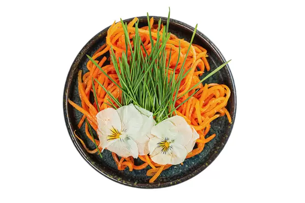 Salad plate with wheat germ, carrots and edible flowers on white, top view