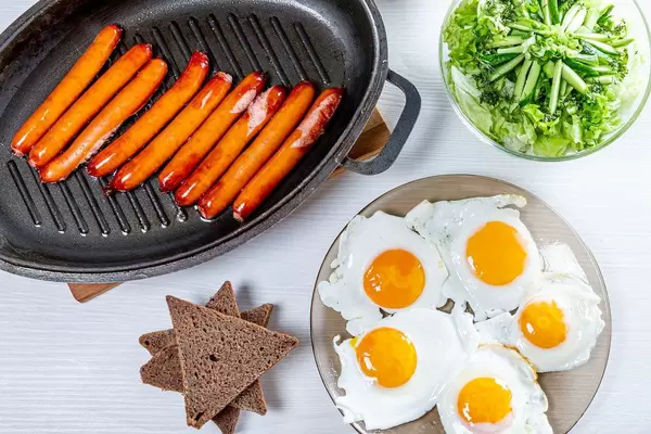 Salad, scrambled eggs and sausages with bread on the table (Flip 2019)