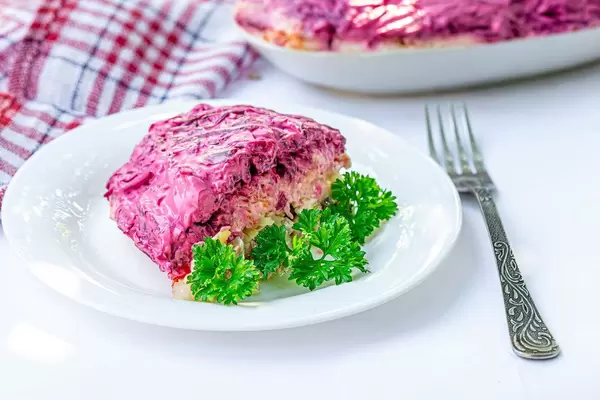 Salad with boiled vegetables and pickled herring with mayonnaise and parsley