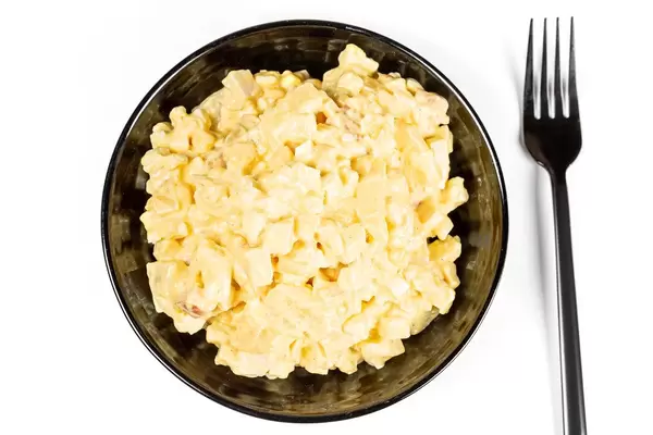 Salad with corn, pineapples, eggs and smoked chicken, top view