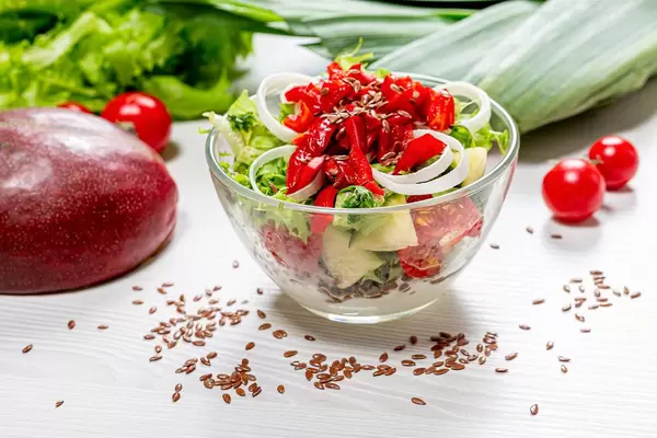 Salad with fresh lettuce, pepper, tomatoes and mango with flax seeds and yogurt (Flip 2019)